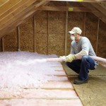 contractor installing spray foam insulation in large attic
