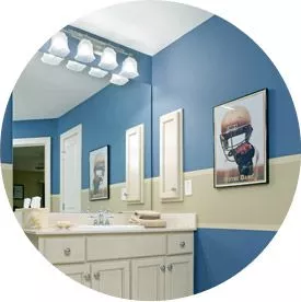 round image of kids bathroom with blue wall and large single vanity
