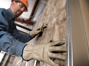 close up of gloved contractor working on insulation