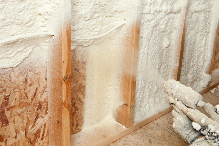 spray foam insulation being sprayed into an unfinished wall.