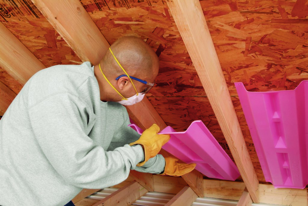 Technician installing attic ventilation.