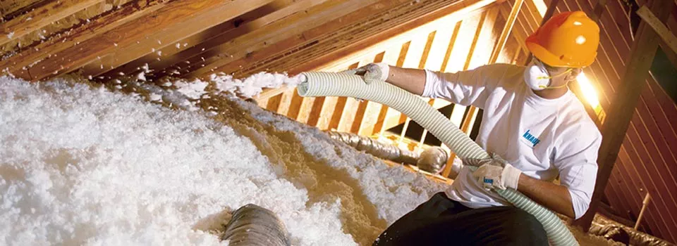 contractor in yellow hard hat spraying insulation