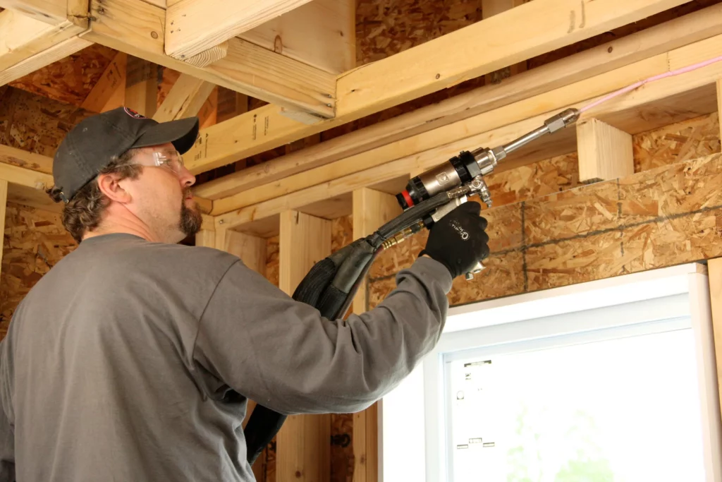 Technician air sealing a home.